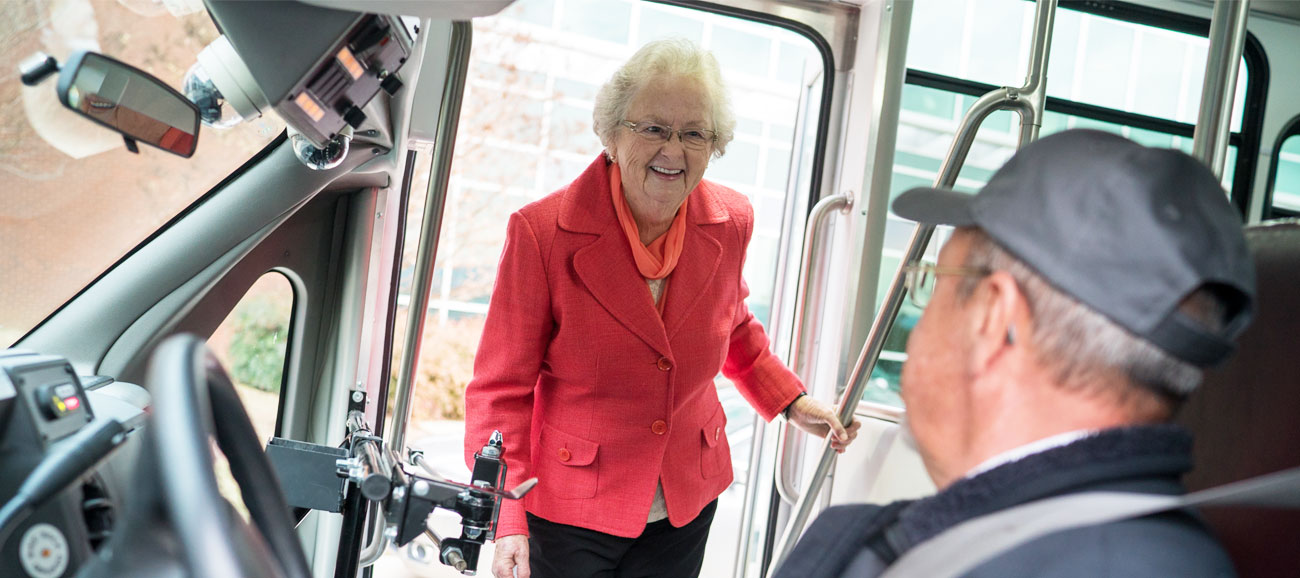 elderly woman getting on the bus